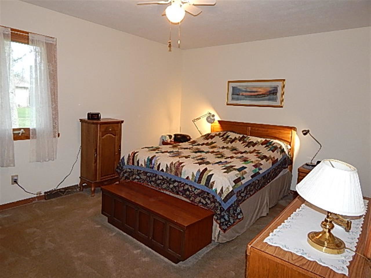 9925 Bitterroot Road Roscoe, IL 61073 - Photo 15 of 25 a bedroom with a bed and dresser with wooden floor