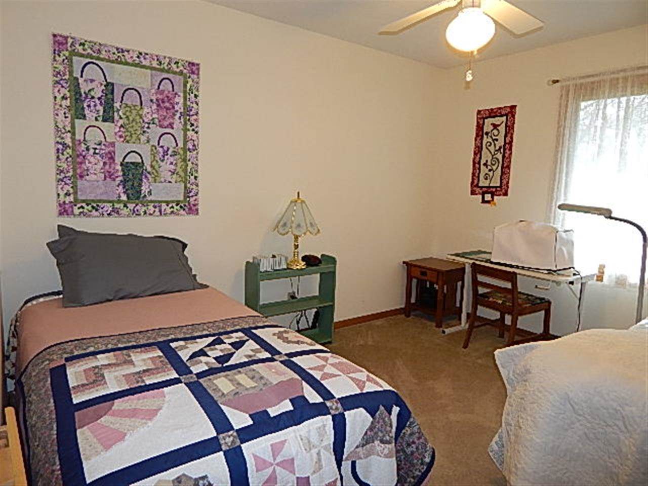 9925 Bitterroot Road Roscoe, IL 61073 - Photo 17 of 25 a bedroom with a bed and a table in it