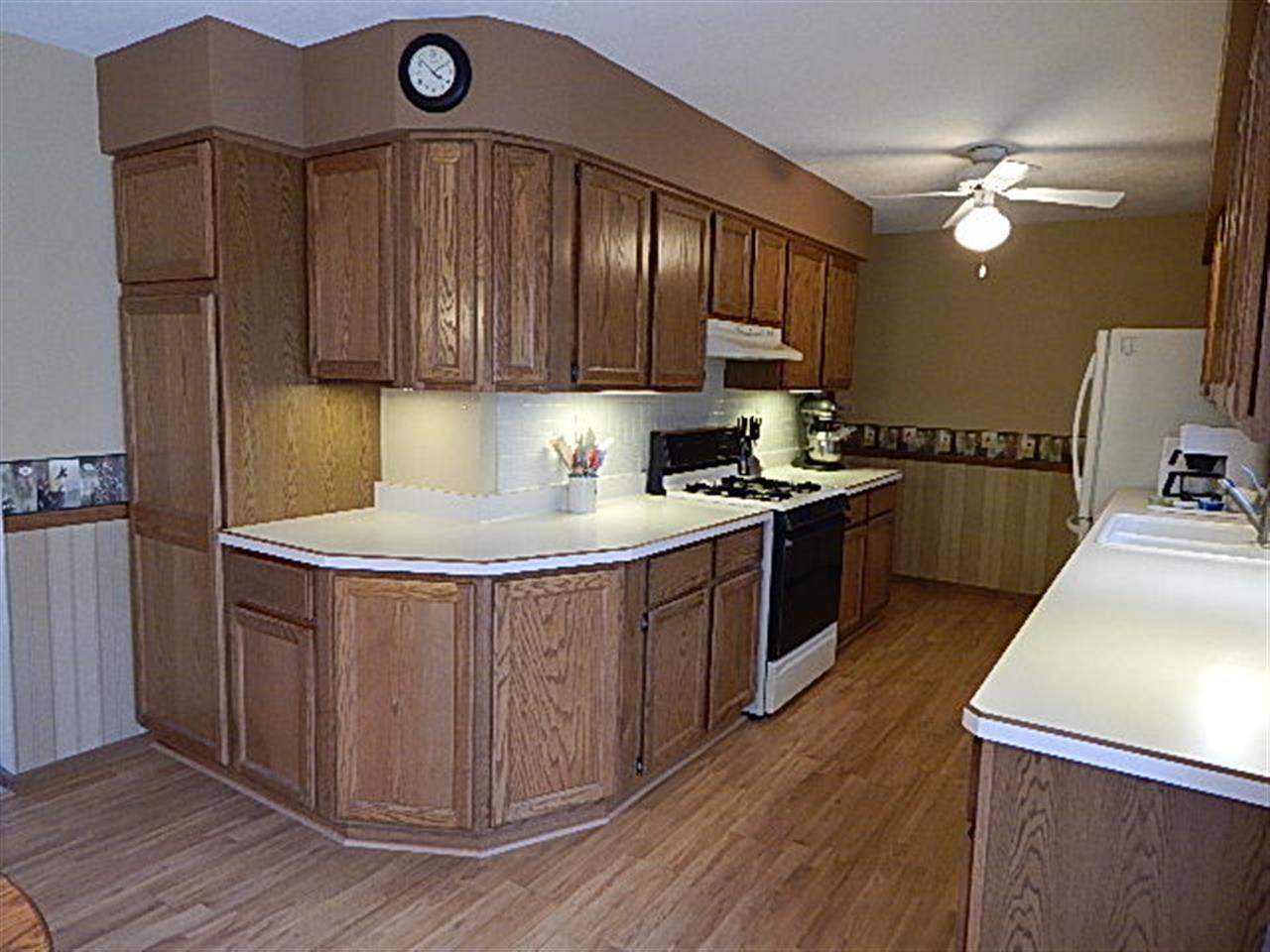 9925 Bitterroot Road Roscoe, IL 61073 - Photo 5 of 25 a kitchen with stainless steel appliances granite countertop a stove a sink dishwasher and a refrigerator with wooden floor
