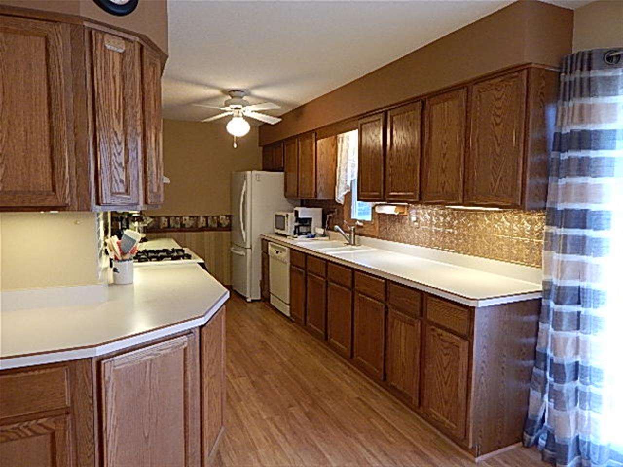 9925 Bitterroot Road Roscoe, IL 61073 - Photo 7 of 25 a kitchen with a sink stove and cabinets