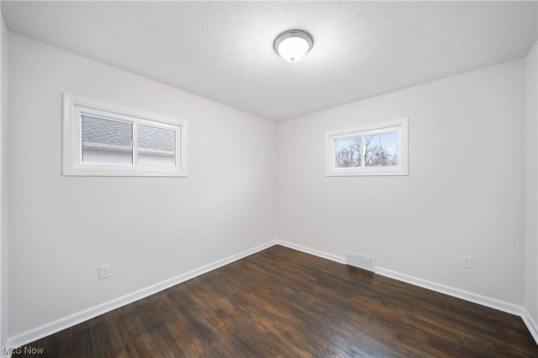 684 Sterling Road Wickliffe, OH 44092 - Photo 19 of 35 Spare room featuring dark hardwood / wood-style flooring and a textured ceiling