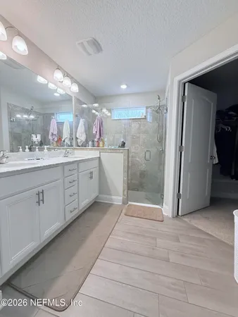 a bathroom with a double vanity sink mirror and shower