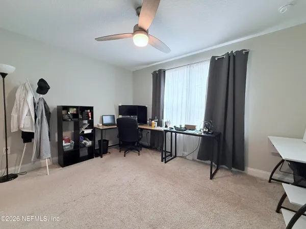 a view of a workspace with furniture and a window