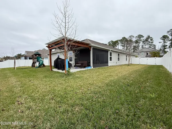 a view of a house with a big yard and large trees