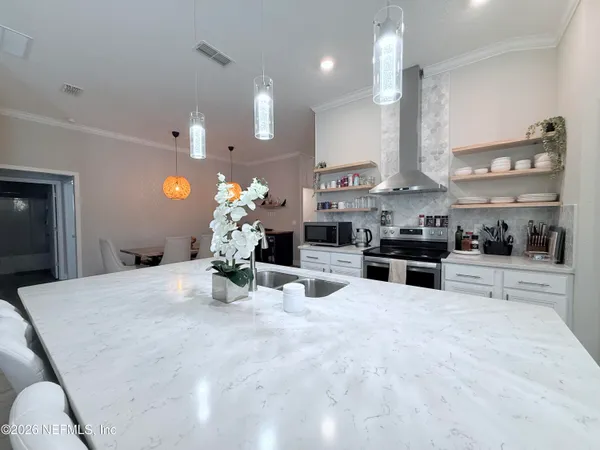 a kitchen with stainless steel appliances kitchen island granite countertop a stove a sink and a refrigerator