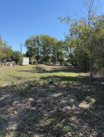 a view of a big yard with large trees