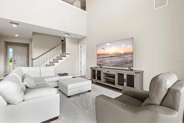 a living room with furniture and a view of kitchen