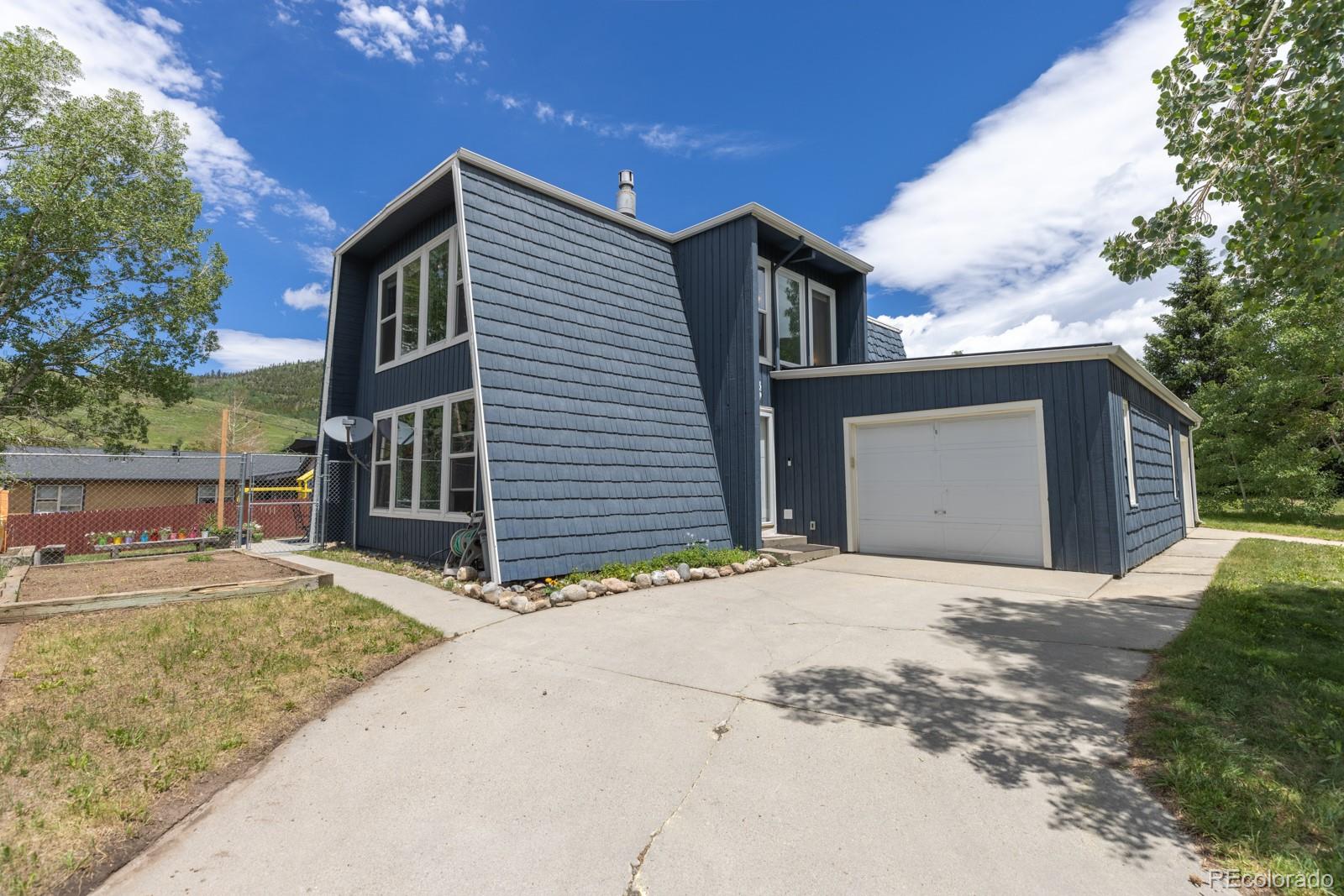 213 Big Elk Road Dillon, CO 80435 - Photo 1 of 50 a front view of a house with a yard and garage