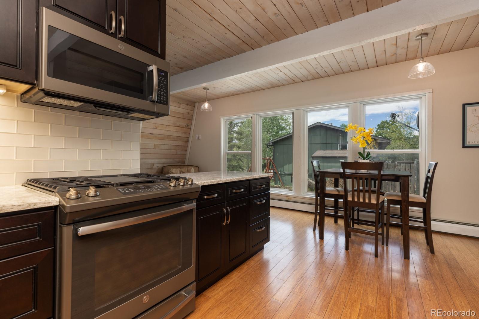 213 Big Elk Road Dillon, CO 80435 - Photo 8 of 50 a kitchen with a stove a microwave and wooden floor