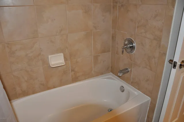 a bathroom with a white bath tub and a shower