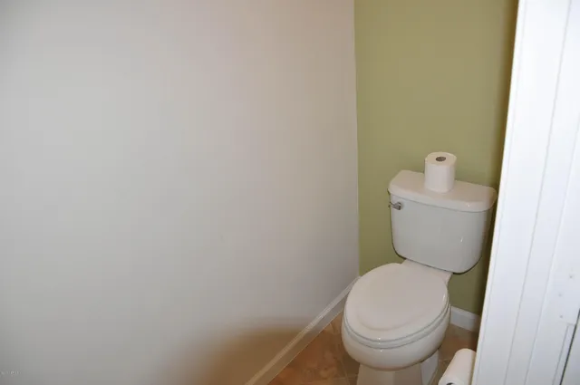 a white toilet sitting next to a white wall
