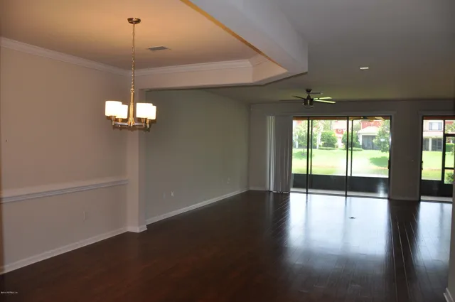 a view of a livingroom with a large window hardwood floor and a ceiling fan