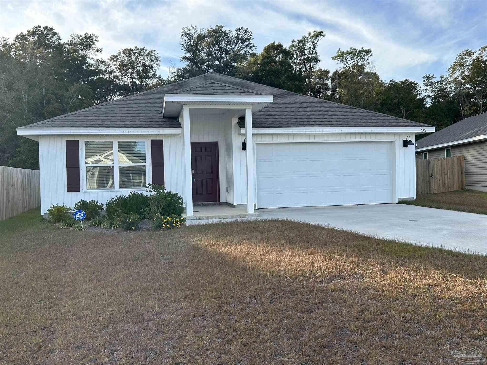 5351 Peach Drive Pace, FL 32571 - Photo 1 of 24 a front view of a house with a yard and garage