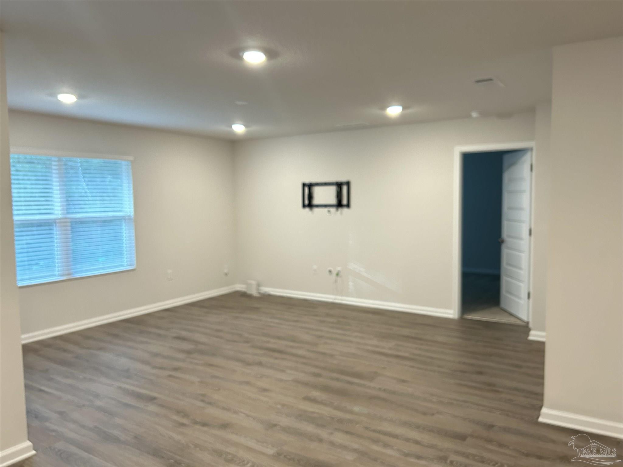 5351 Peach Drive Pace, FL 32571 - Photo 4 of 24 an empty room with wooden floor and windows