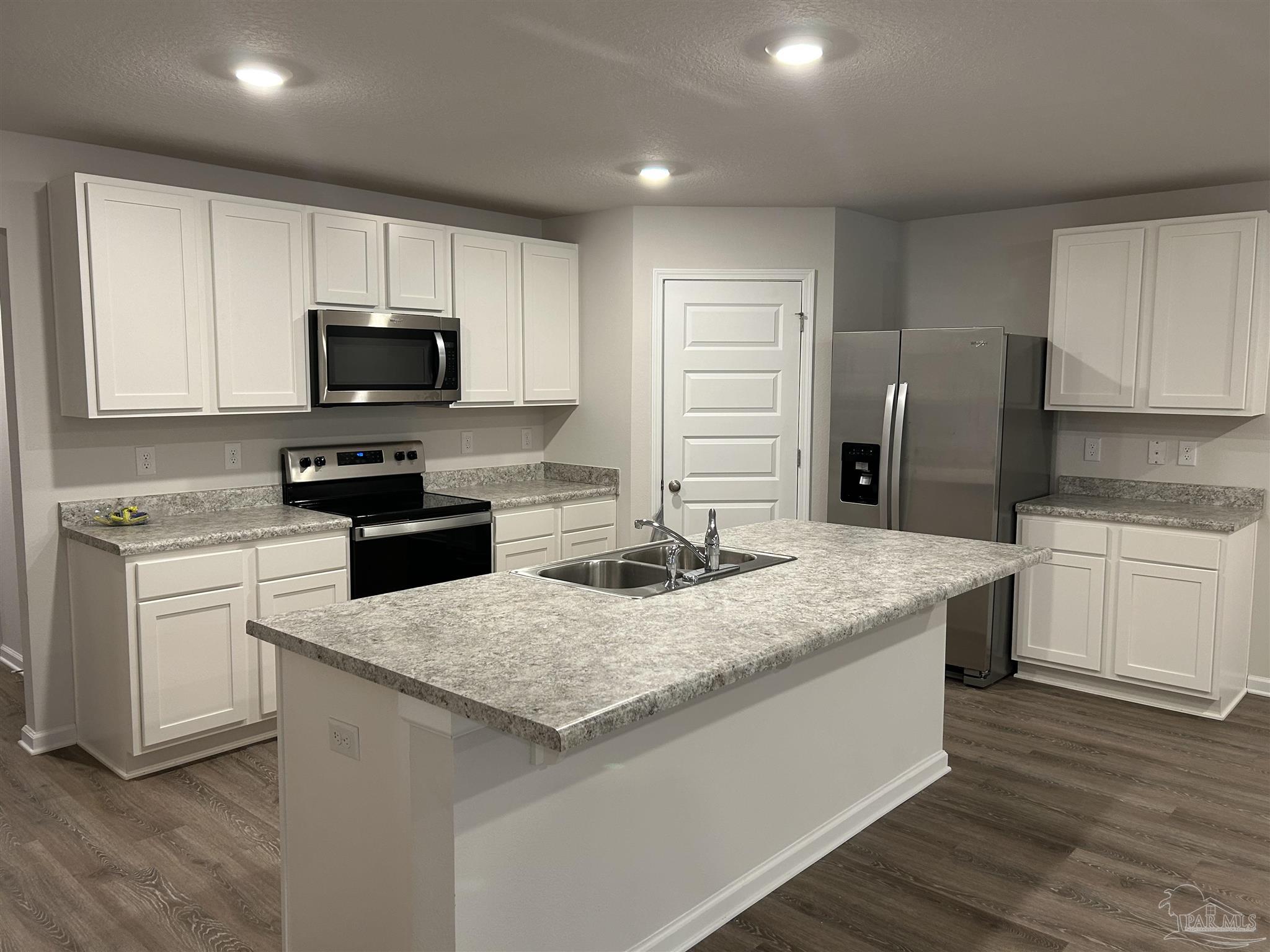 5351 Peach Drive Pace, FL 32571 - Photo 6 of 24 a kitchen with granite countertop white cabinets and stainless steel appliances