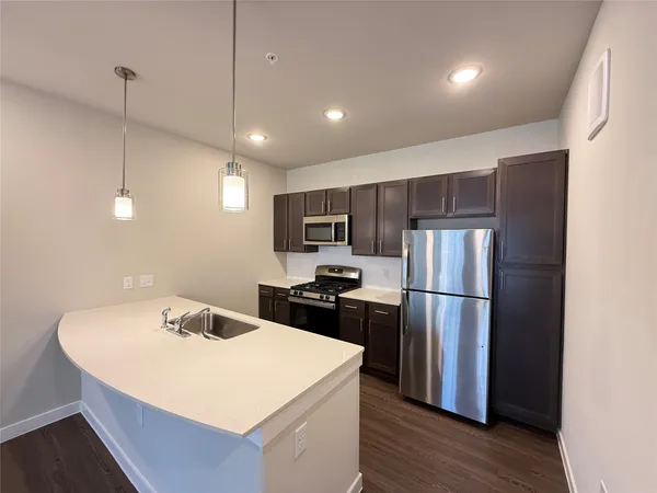 a kitchen with refrigerator cabinets and wooden floor