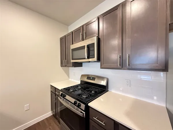a kitchen with granite countertop a stove and a microwave