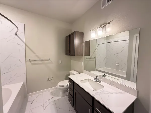 a bathroom with a sink toilet double vanity and shower