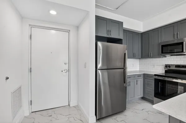 a metallic refrigerator freezer sitting in a kitchen