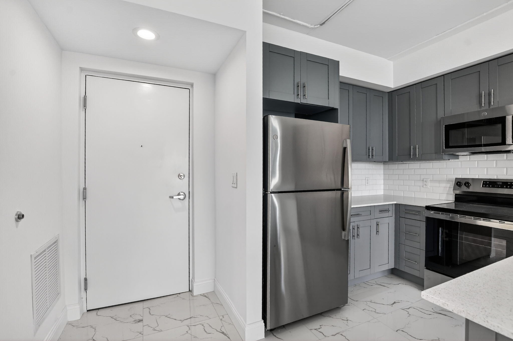 a metallic refrigerator freezer sitting in a kitchen