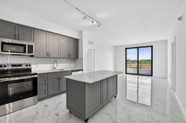 a kitchen with stainless steel appliances granite countertop a stove a sink and a microwave