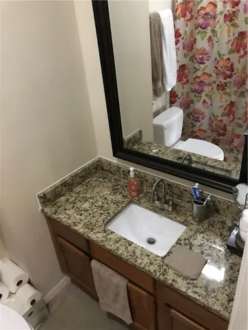 a bathroom with a granite countertop sink and a mirror