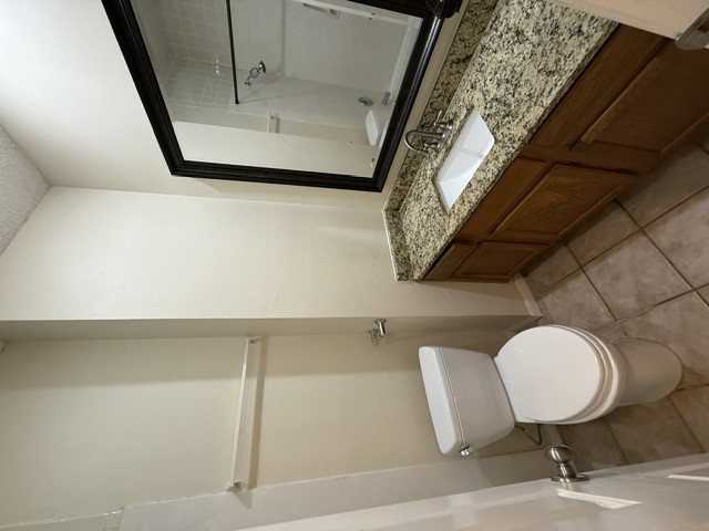 2300 Leon Street, Unit 202 Austin, TX 78705 - Photo 13 of 19 a bathroom with a granite countertop sink toilet and a mirror