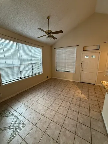 a view of an empty room and window chandelier fan