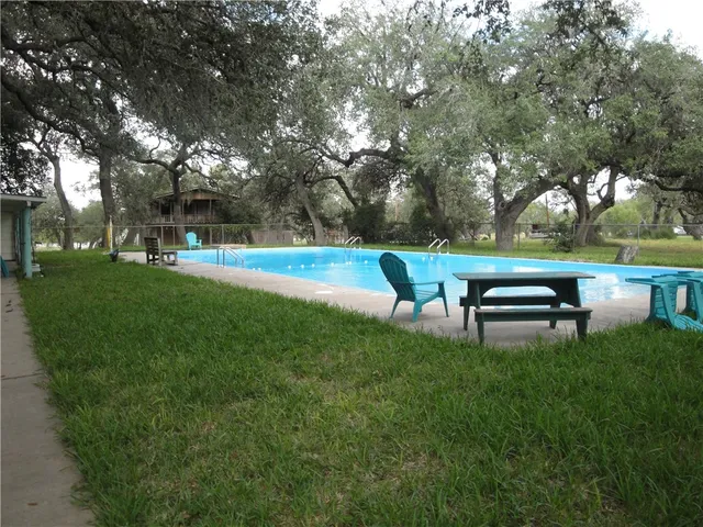 a swimming pool with outdoor seating and yard