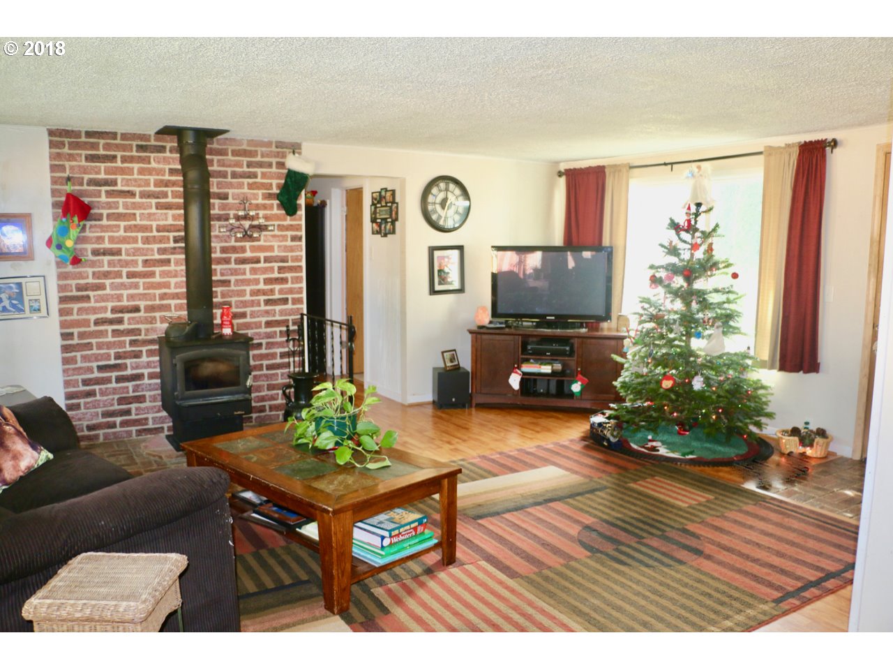 885 25th Place Springfield, OR 97477 - Photo 7 of 15 a living room with furniture a flat screen tv and a potted plant