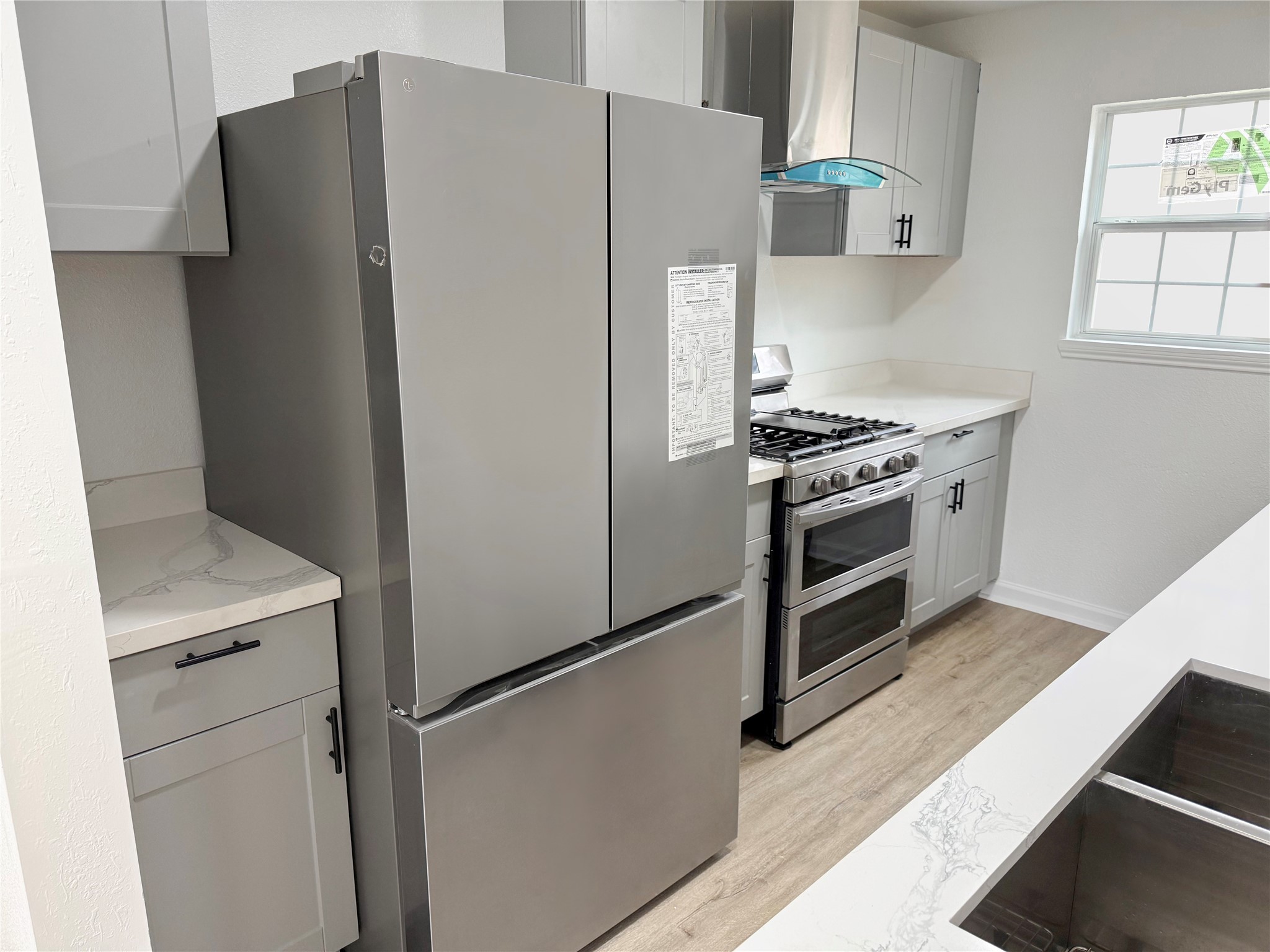 301 County Road 2734 Cleveland, TX 77327 - Photo 6 of 17 a white refrigerator freezer and a stove sitting inside of a kitchen
