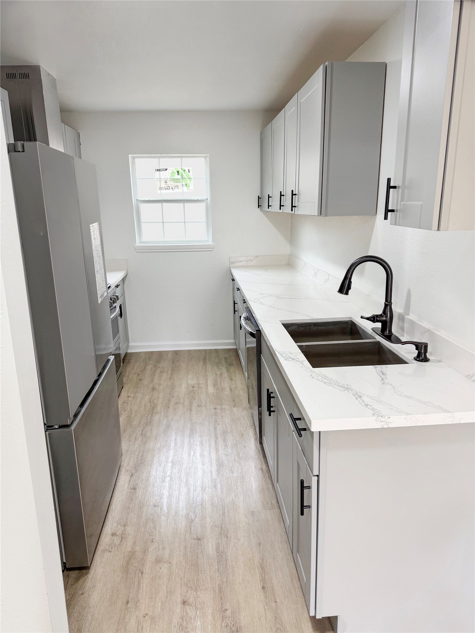 301 County Road 2734 Cleveland, TX 77327 - Photo 8 of 17 a kitchen with a sink a refrigerator and window