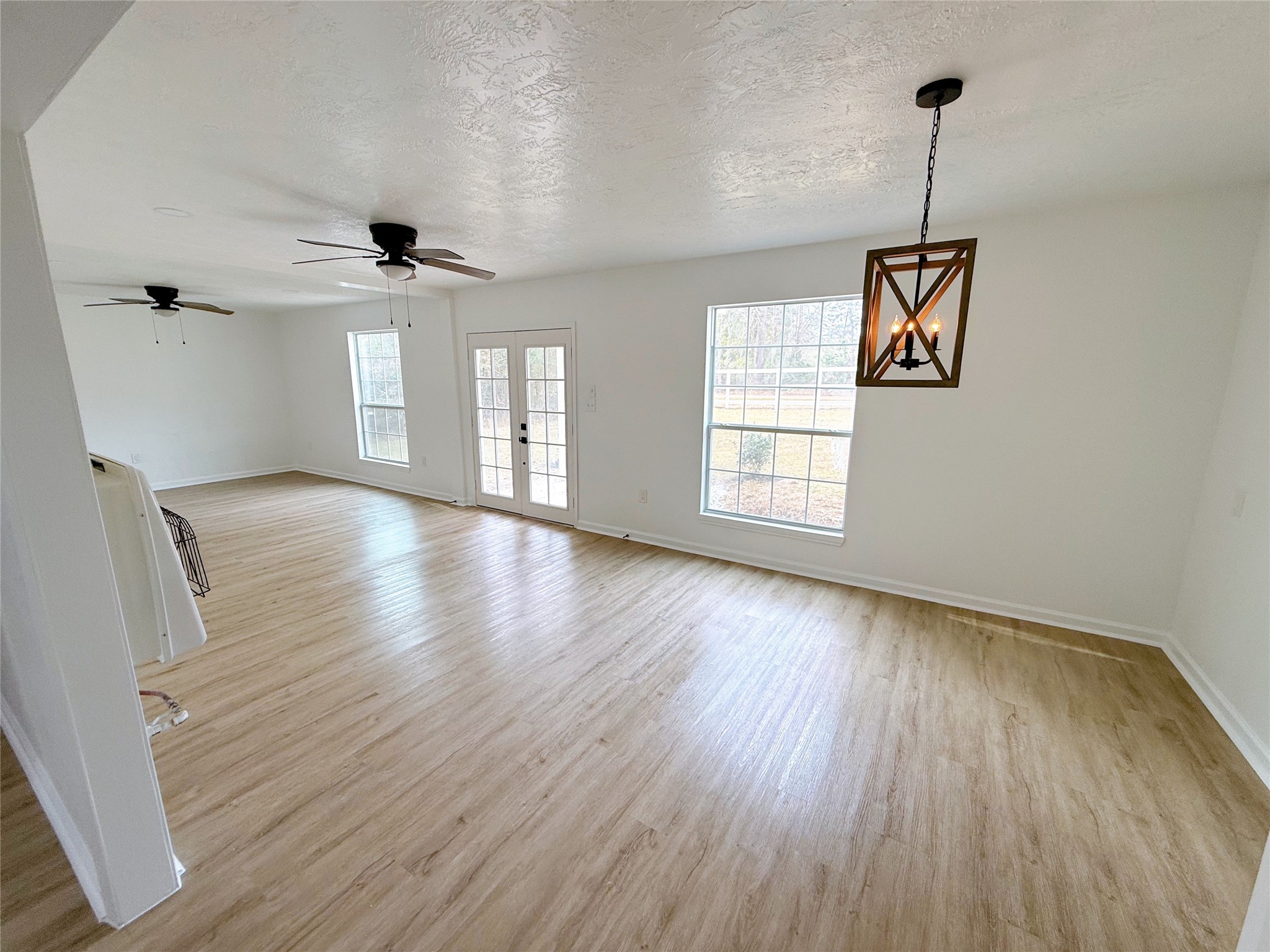 301 County Road 2734 Cleveland, TX 77327 - Photo 10 of 17 an empty room with wooden floor and windows