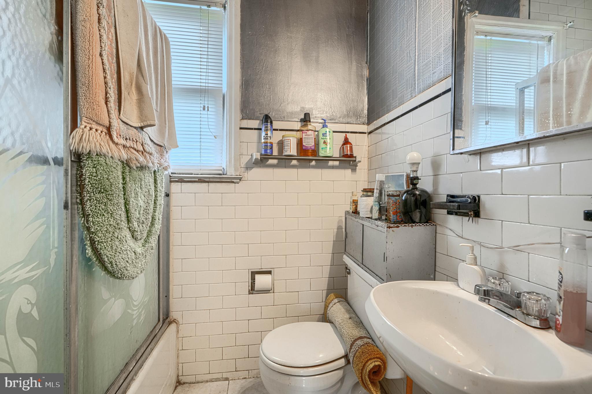 3212 Dorchester Road Baltimore, MD 21215 - Photo 33 of 45 a bathroom with a sink a toilet and shower