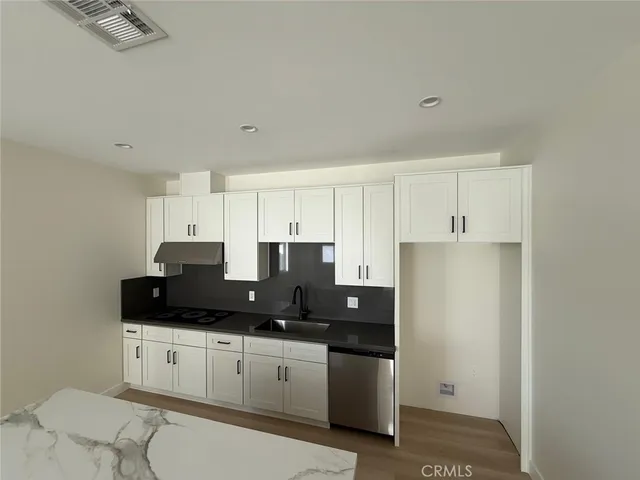 a kitchen with granite countertop white cabinets and black appliances