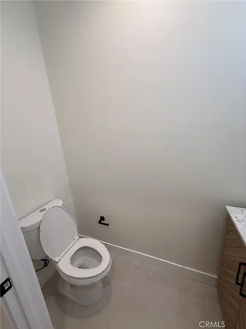a view of a hallway with wooden floor and bathroom