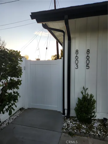 a view of a door and car parked in the road