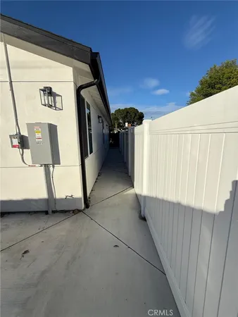 a view of a refrigerator in kitchen and an empty room