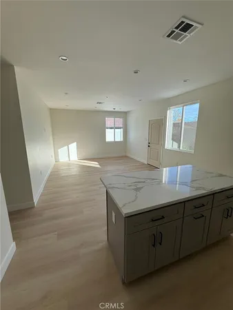 a view of an empty room with wooden floor and a cabinet
