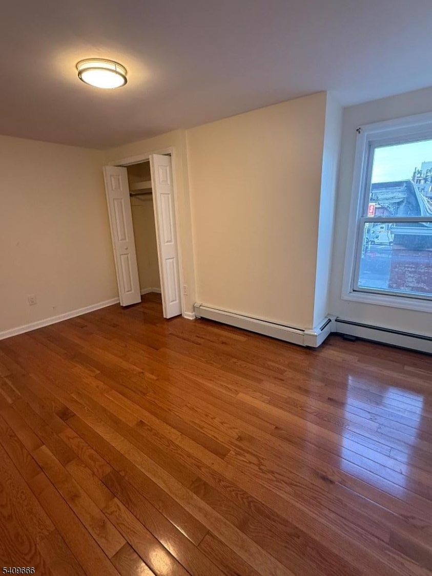 30 Elm Street, Unit 2 Newark, NJ 07102 - Photo 4 of 10 an empty room with wooden floor and windows
