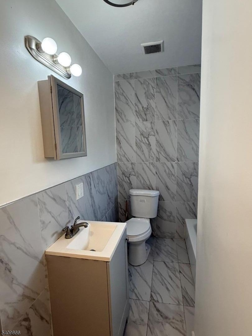 30 Elm Street, Unit 2 Newark, NJ 07102 - Photo 7 of 10 a bathroom with a toilet sink and mirror