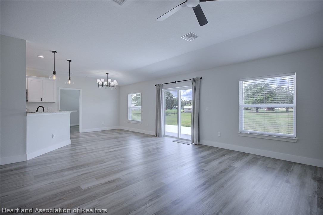 111 Vale Court Sebring, FL 33876 - Photo 7 of 40 an empty room with wooden floor and windows
