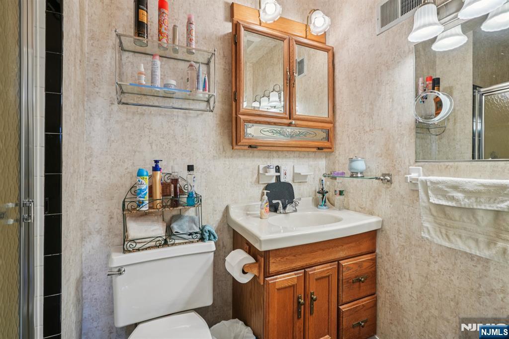 181 Long Hill Road, Unit K5 Little Falls, NJ 07424 - Photo 18 of 48 a bathroom with a sink a toilet and a mirror