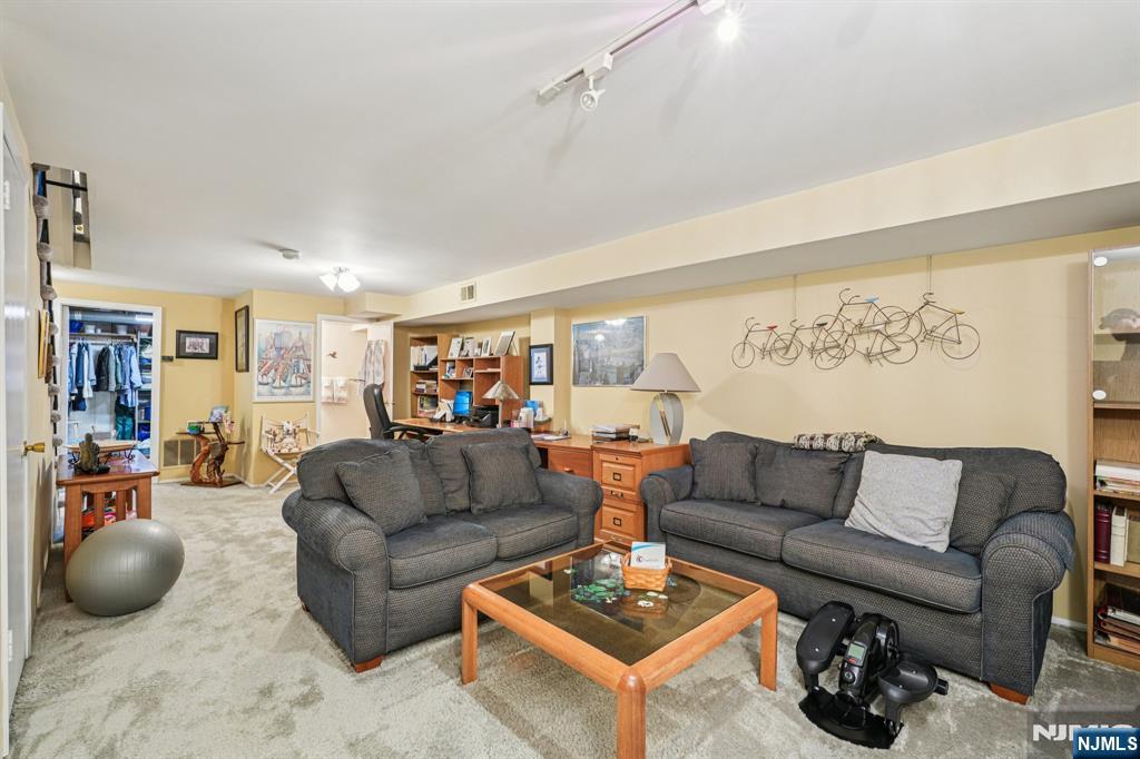 181 Long Hill Road, Unit K5 Little Falls, NJ 07424 - Photo 26 of 48 a living room with furniture a rug and white walls