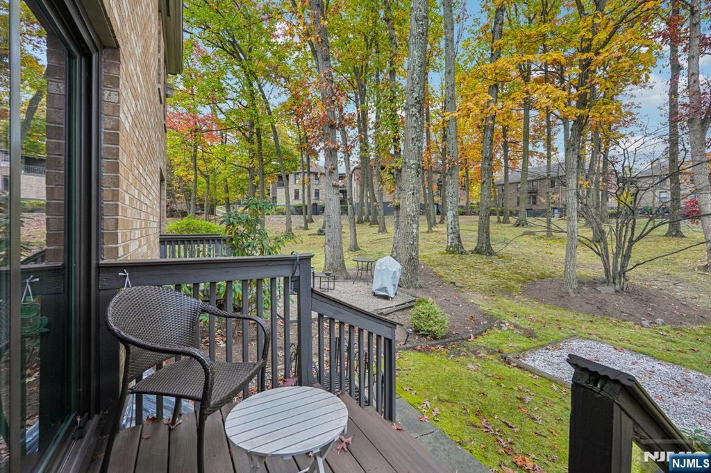 181 Long Hill Road, Unit K5 Little Falls, NJ 07424 - Photo 30 of 48 a view of a patio with a table chairs and a floor to ceiling window