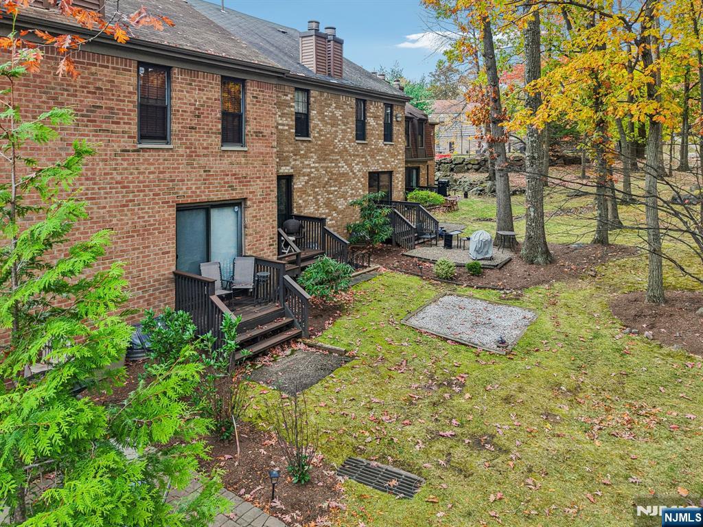 181 Long Hill Road, Unit K5 Little Falls, NJ 07424 - Photo 35 of 48 a view of a backyard with table and chairs potted plants and a large tree