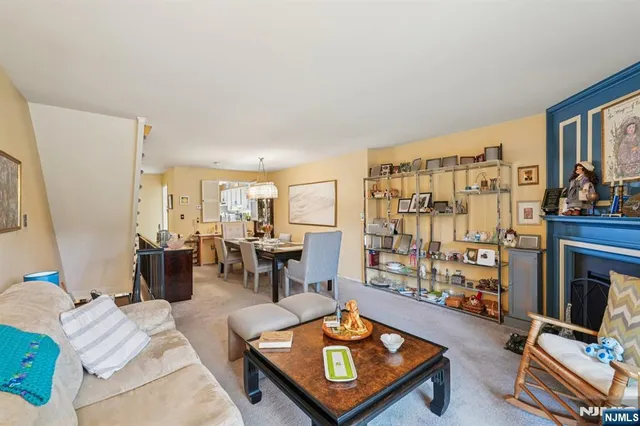 a living room with furniture kitchen view and a wooden floor