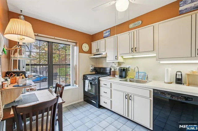 a kitchen with stainless steel appliances kitchen island granite countertop a table chairs and a refrigerator