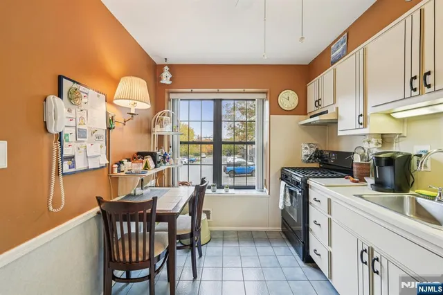 a kitchen with white cabinets and white appliances
