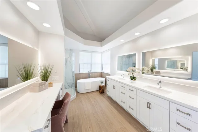 a spacious bathroom with double vanity a large mirror a vanity and a bathtub
